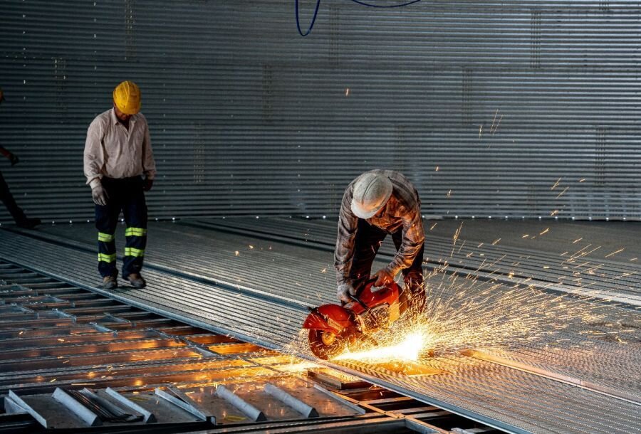 Workers installing grain bin floor with safety gear